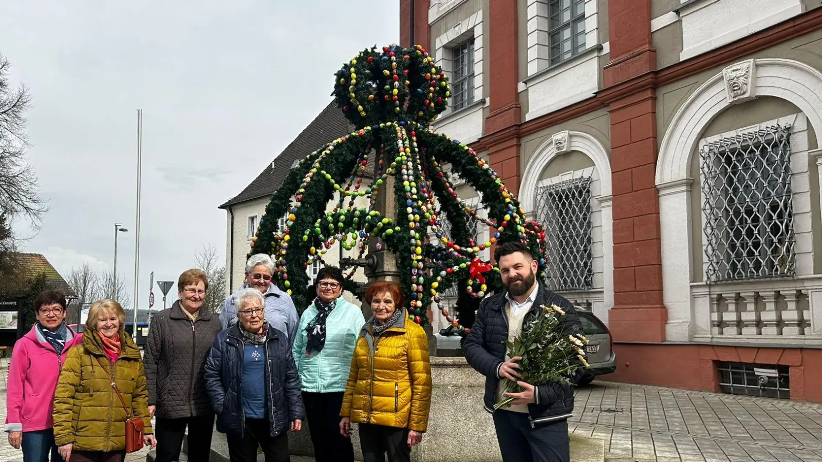 Marianne Lebegern, Gabi Fröhlich, Elisabeth Schmid, Christa Schmidberger, Sieglinde Lang, Meta Fichtner, Angela Schmal und Bürgermeister Sebastian Dippold stehen stolz vor dem Osterbrunnen am Stadtplatz in Neustadt/WN.  (Bild: Ramona Herrmann/exb)