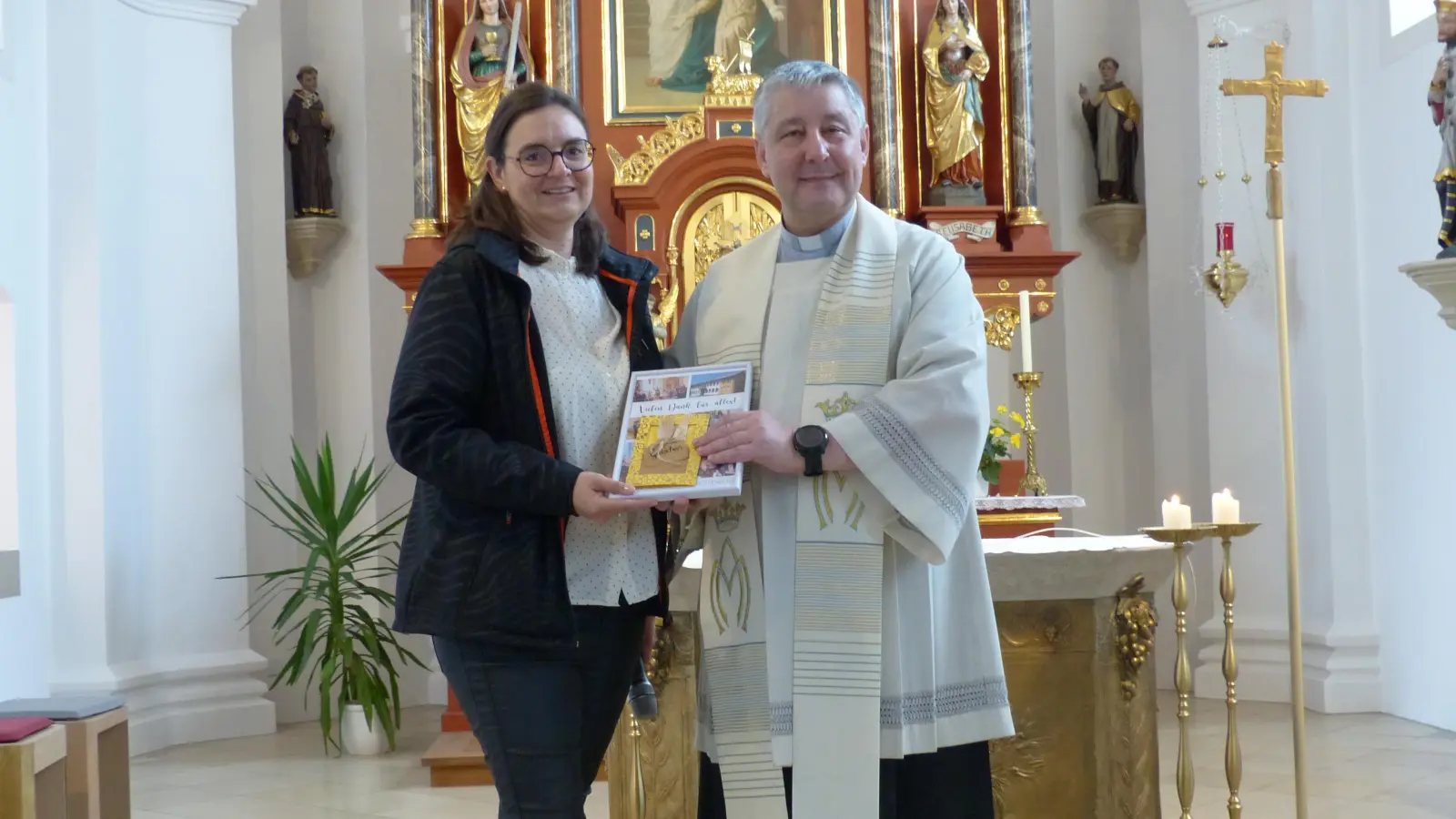 Schulleiterin Katja Meidenbauer überreicht an Pfarrer Adam Nieciecki zum Dank und zum Abschied ein Geschenk. (Bild: Sieglinde Schärtl)