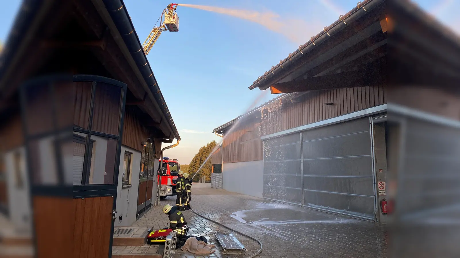 Der Löschangriff der Feuerwehren am Pferdegestüt in Neunkirchen läuft über die Drehleiter und über die Trupps am Boden. (Bild: Gerd Miederer)