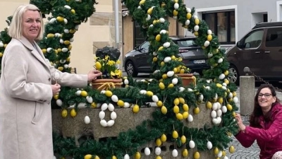 Barbara Hößl-Bauer (rechts) und Claudia Wolf (links) verpassten dem Osterbrunnen den letzten Schliff, so dass sich Besucher des Rathauses oder Spaziergänger sich an dem leuchtenden Anblick erfreuen können.  (Bild: myd)