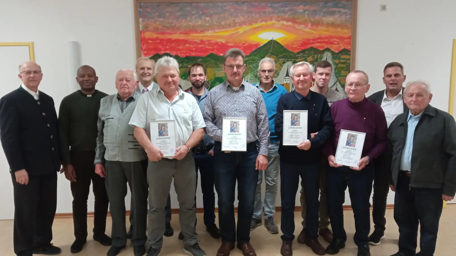 Zum Erinnerungsfoto stellten sich Geehrte (mit Urkunde von links) Erich Ostermeier, Andreas Kick, Walter Hanauer, Josef Nößner zusammen mit Ehrengästen (von links) Pfarrer Herbert Rösl, Pfarrvikar Kenneth, Gründungsmitglied Georg Schottenheim, Ehrenobmann Johann Neuber (und von rechts) Altbürgermeister Josef Klier, 1. Bürgermeister Norbert Eckl sowie Mitarbeiter (4. v. rechts) Georg Kühner, (6. von rechts) Rudi Kleber und (6. von links) Thomas Kühner auf.  (Bild: Hans Kiesl)