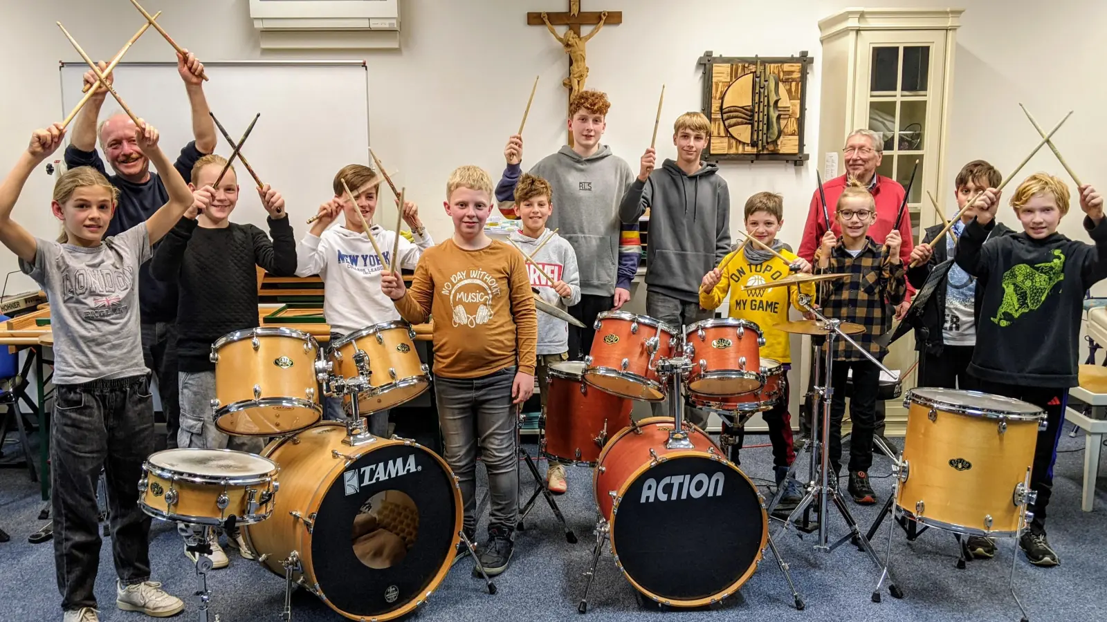 Die Sticks in die Lüfte zeigen die engagierten Schützlinge mit ihrem professionellen Musiklehrer und Naturfilmer Thomas Stock (links, hinten) beim Schülervorspiel der Neustädter Musikschule. (Bild: Karl Wildenauer)