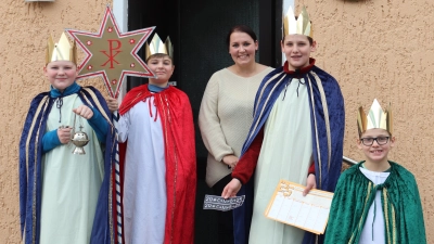 Die Sternsinger Simon (v.l.), Philipp, Maximilian und Tobias überbringen den Segen unterwegs auf ihrer Mission bei Familie Kölbl am Riedener Marktplatz (Bild: Michael Rabenhofer)