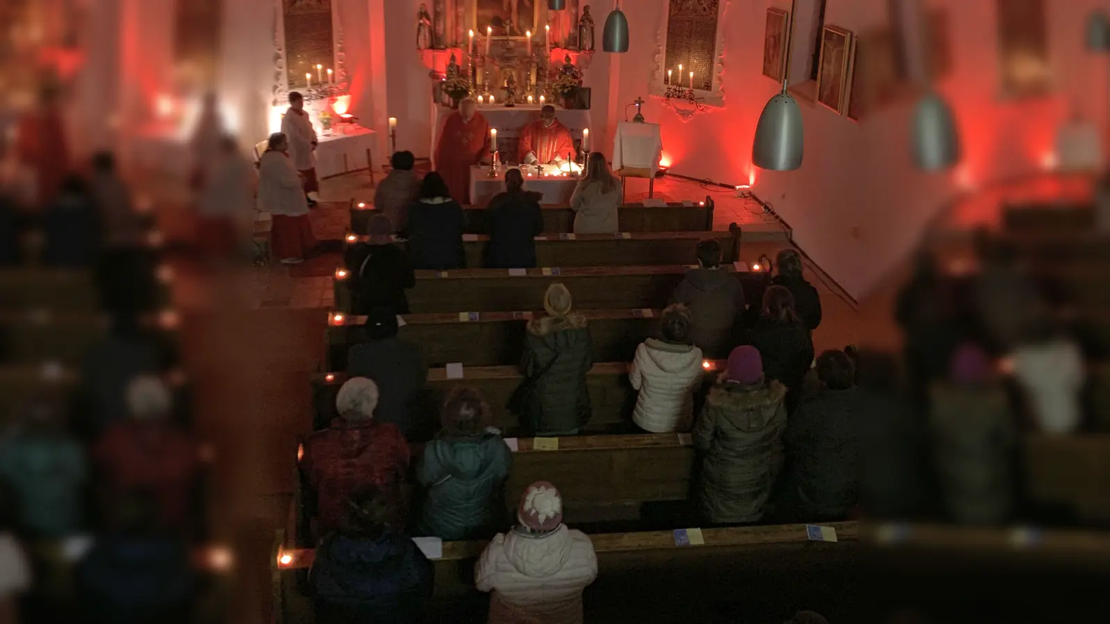 In der rot angestrahlten Sebastiankapelle setzten die Pfarrangehörigen im Gebeet ein klares Zeichen für das Menschenrecht auf Religionsfreiheit. (Bild: Karl Ziegler)