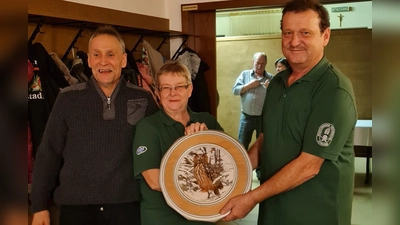 Erster Schützenmeister Helmut Werner (rechts) und zweiter Schützenmeister Michael Knott überreichen die letzte Ehrenscheibe der Jahres 2023 an die sichtlich erfreute Sieglinde Knott.<br> (Bild: Kerstin Werner/exb)