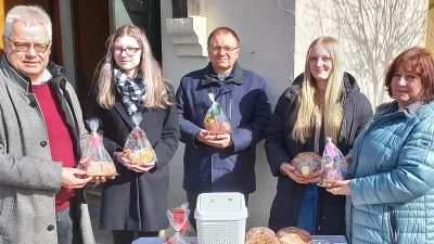 Roman Melzner (links), Zweiter Vorsitzender des Fördervereins Kinderheim Bana, bedankte sich am Ostersonntag mit Pfarrer Markus Bruckner (Mitte) bei den vielen fleißigen Händen des Krippenspielteams bei ihrer traditionellen Osterlamm-Aktion. (Bild: mez/exb)