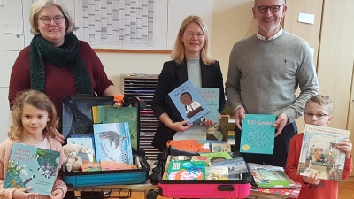 Maria Sagstetter (links) vom Pfarrgemeinderat, Rektorin Karin Gleißner, Stadtpfarrer Dr. Thomas Vogl und Schüler bei der Übergabe von spendenfinanzierten Bücherkoffern an die Grundschule Waldsassen.  (Bild: Pfarramt Waldsassen/exb)