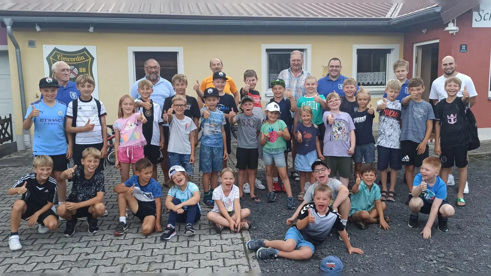 Die Kinder stellten sich zum Gruppenfoto vor dem Vereinsheim mit den Betreuern im Hintergrund sowie Jugendbeauftragten Manuel Ernst hinten rechts.  (Bild: Martin Dietz)