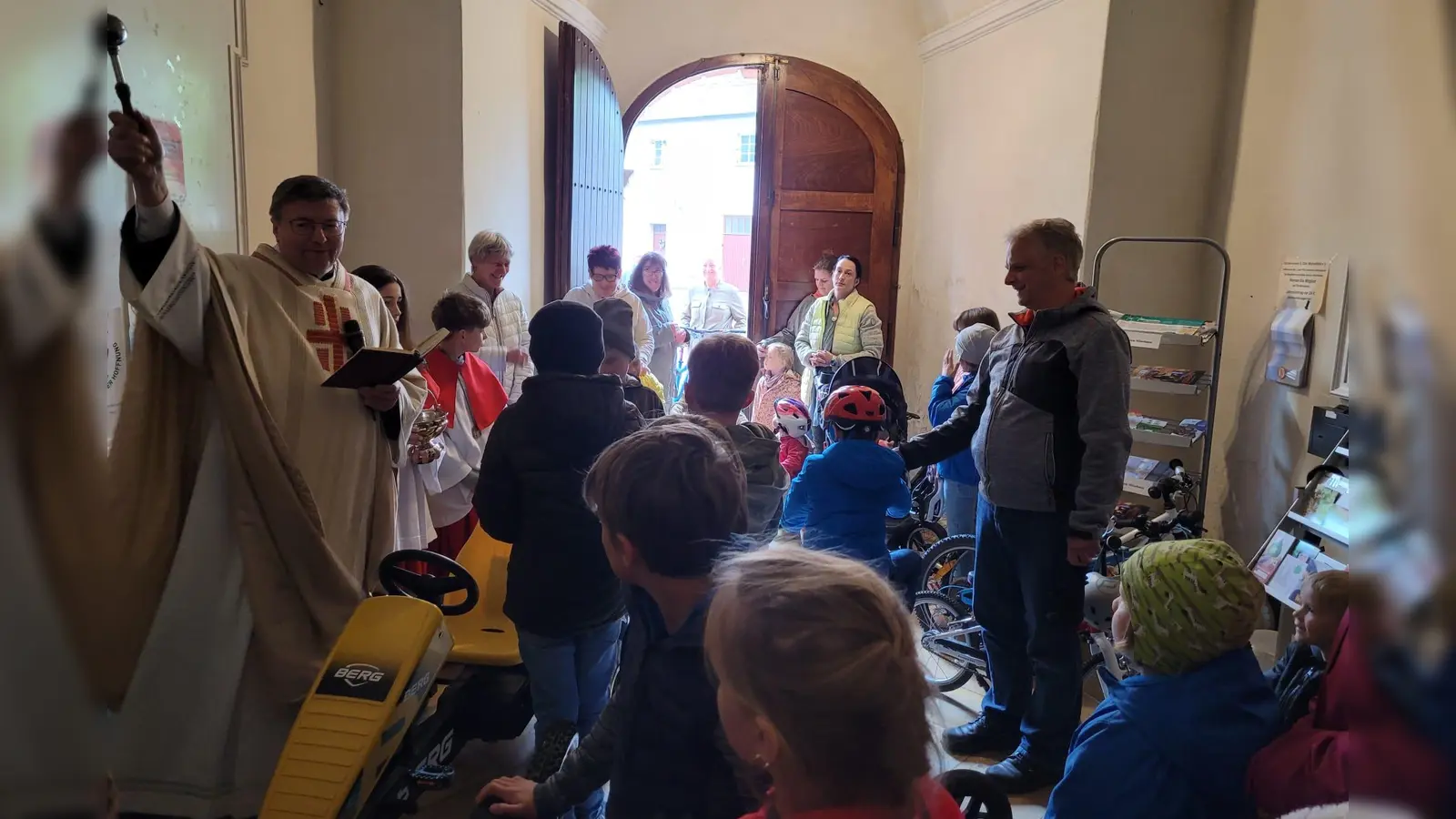 Ortspfarrer Pater Markus Flasinski segnete im Vorraum der Pfarrkirche die Fahrzeuge, die die Kinder mitgebracht hatten. (Bild: Regina Lord)