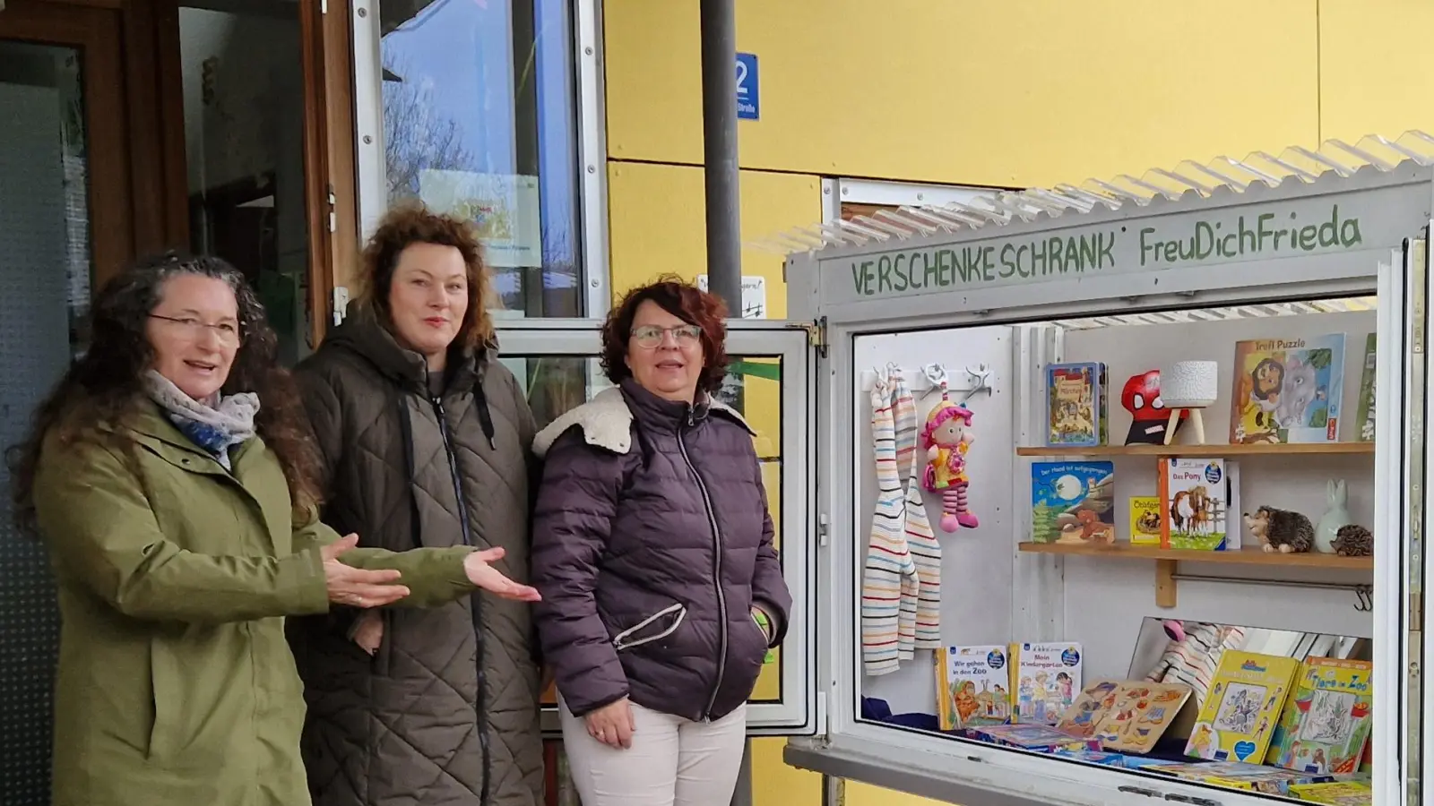 Der gefüllte Geschenkeschrank beim Kindergarten in Lintach, mit (von nlinks) Margit Haberberger, Mitgründerin des Verschenkeschankes, sowie Ulrike Schlaffer und Ulrike Schießlbauer vom Kindergarten St. Walburga in Lintach. (Bild: jow)