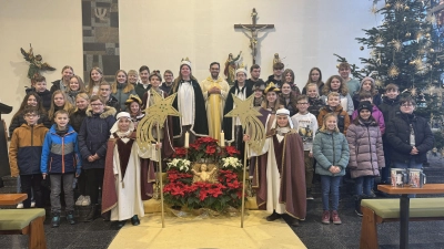 Pfarrer Dominik Mitterer inmitten einem Teil seiner Sternsinger.  (Bild: Valentin Böhm/exb)