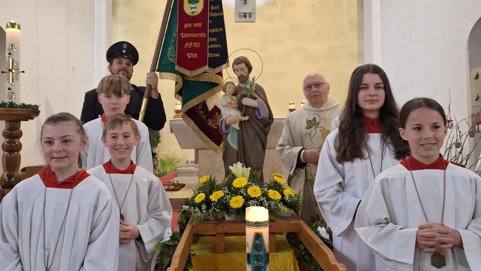 Zum Patrozinium der Bechtsriether Kirche wird die Figur des heiligen Josef geschmückt. Pfarrer Andreas Hanauer, die Ministranten und die Fahnenabordnung der Feuerwehr steh stolz daneben.  (Bild: Alfred Wulfänger/exb)