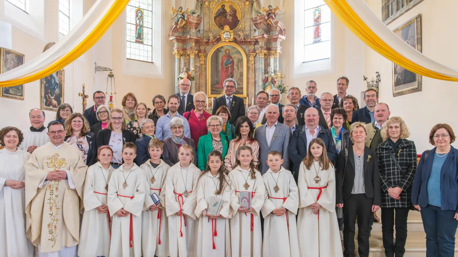 Pastoralreferentin Maria Wagner, Kommunionhelfer Tobias Franz und Pfarrer Konrad Amschl (von links) sowie die diesjährigen Erstkommunionkinder freuten sich mit den Jubelkommunikanten. (Bild: ws-fotografie/exb)